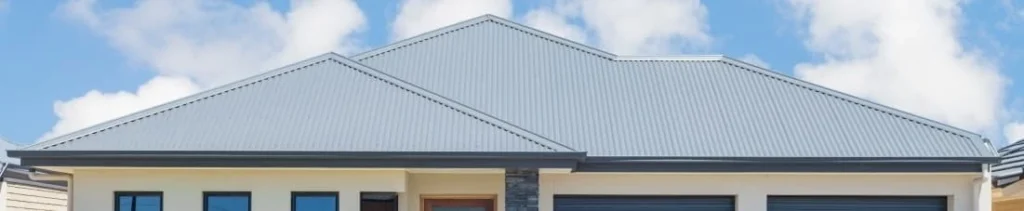 Side-by-side comparison of old rusted corrugated roof and newly refurbished clean metal roof.