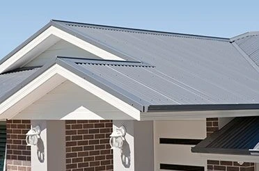 Modern brick home with a light-colored metal roof and gable design