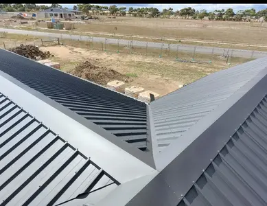 Newly installed dark metal roof with detailed ridge flashing