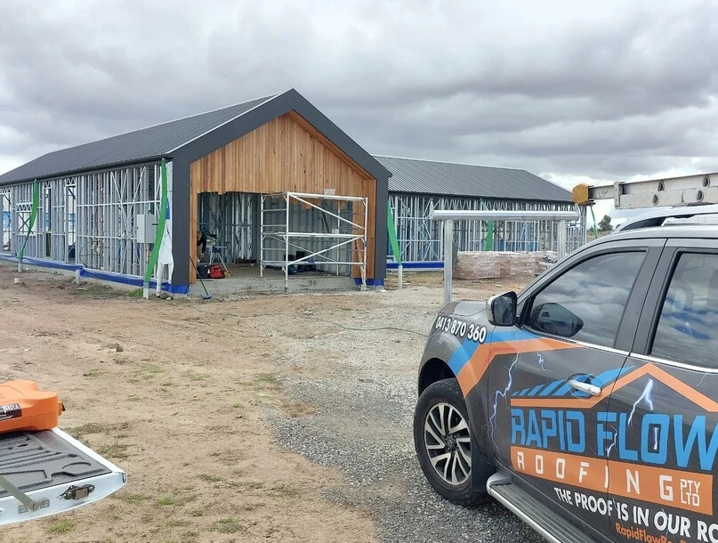 Rapid Flow Roofing vehicle at a residential metal roofing project during construction.