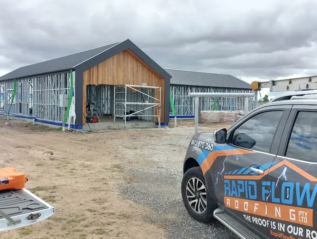 Rapid Flow Roofing vehicle at a residential metal roofing project during construction.